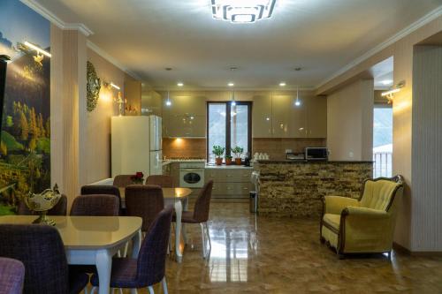 卡兹贝吉Hotel Diamond Kazbegi的厨房以及带桌椅的起居室。