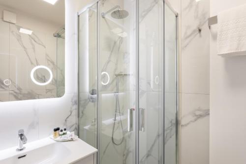 代森扎诺-德尔加达Hotel Aquila D'Oro Desenzano的带淋浴和盥洗盆的白色浴室