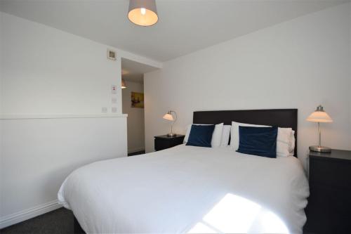托伯莫里Puffin Apartment的卧室配有带蓝色枕头的大型白色床