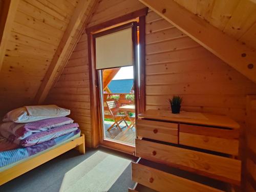 乌斯特卡Domki Letniskowe Promyk的小木屋内一间卧室,配有一张床和一个窗户