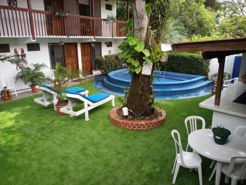 萨玛拉卡萨德尔玛住宿加早餐旅馆的后院设有游泳池、桌子和椅子