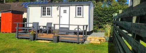 巴尔马卡拉Cozy Shepherd hut 20 by 7 feet with boxed in high double bed的院子中带甲板的小房子