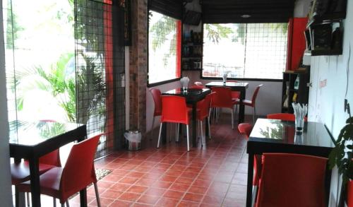 卡拉克斯港巴伊亚住宿加早餐旅馆的餐厅设有红色的椅子和桌子以及窗户。