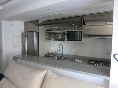 里约热内卢Apartamento luxuoso com infra completa próximo a Praia da Barra da Tijuca的柜台前方配有沙发的厨房