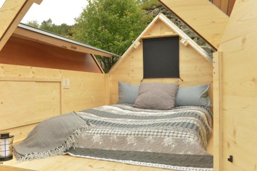 TraversellaStarsBox Valchiusella的木制房屋内的一张床位,设有窗户