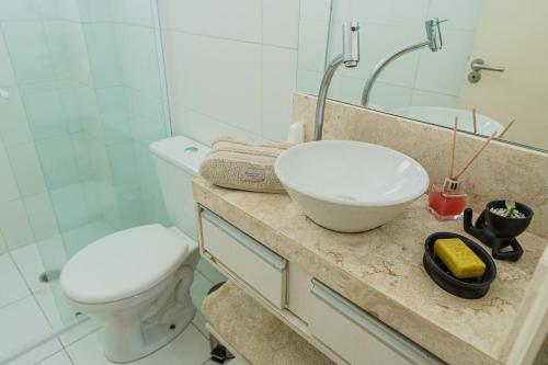 大普拉亚VISTA PRAIA MAR - AVIAÇÃO - 300 metros da praia - WI FI - VARANDA GOURMET com CHURRASQUEIRA - ESTACIONAMENTO gratuito的一间带水槽、卫生间和镜子的浴室