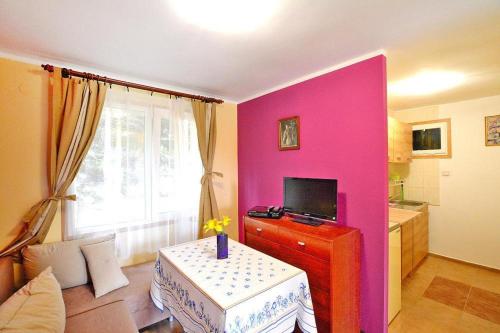 辛安诺泽蒂Bungalow close to the beach Sianozety的客厅设有粉红色的墙壁和桌子