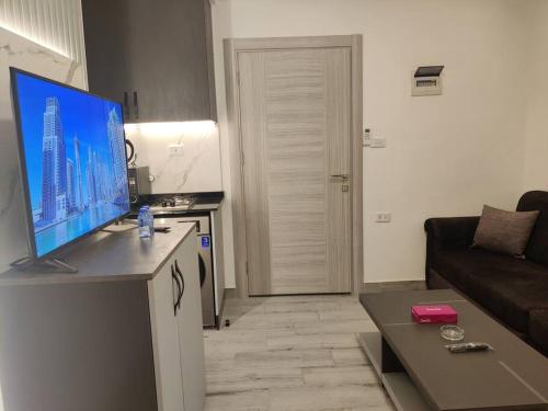安曼46m luxury room near downtown and all services的客厅配有台面上的平面电视
