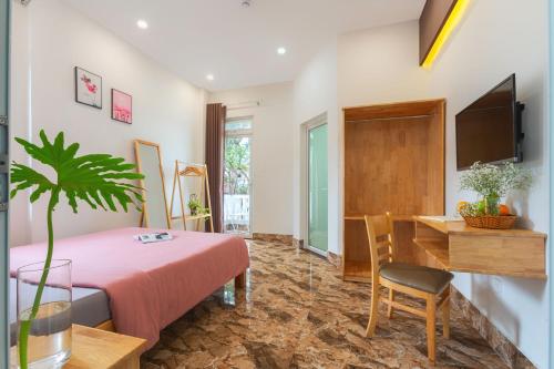 大叻RAON Villa - STAY 24H的一间卧室配有一张床、一张书桌和一台电视
