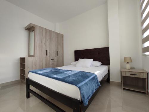 曼塔APARTAMENTO PUERTO MADERA的一间卧室配有一张带蓝色毯子的床
