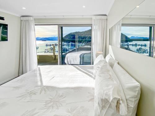 皮克顿Picton Waterfront Apartments的一间卧室设有一张床和一个大窗户