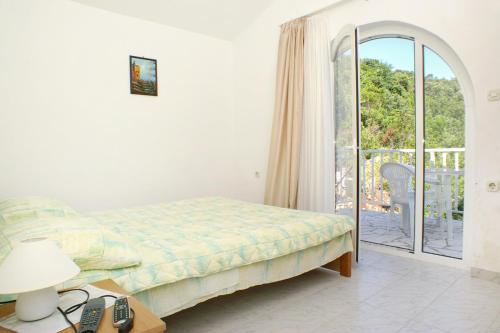 克勒克Apartments by the sea Komarna, Neretva Delta - Usce Neretve - 2739的一间卧室设有一张床,并有通往阳台的门