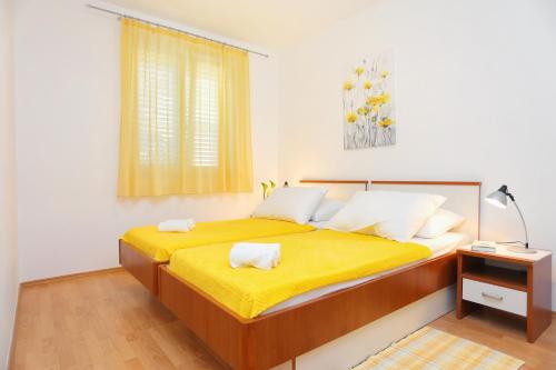 泰斯Apartments by the sea Stanici, Omis - 2764的一间卧室配有一张带黄色床单的大床