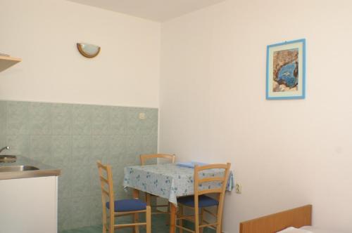 德尔韦尼克Apartments by the sea Drvenik Donja vala, Makarska - 2732的厨房配有桌椅、桌子和水槽