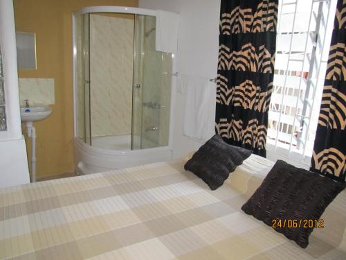Belfast赤足旅馆的带淋浴的浴室以及带黑色枕头的床。