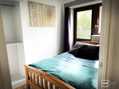 Enfield LockEnfield House - Beautiful 2 Bed - Good Transport Free Parking的一间小卧室,配有一张带窗户的床