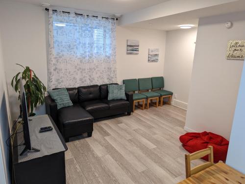 卡尔加里Livingston Howse Haven - A simple & cozy private two-bedroom basement suite with free parking的客厅配有沙发和两把椅子