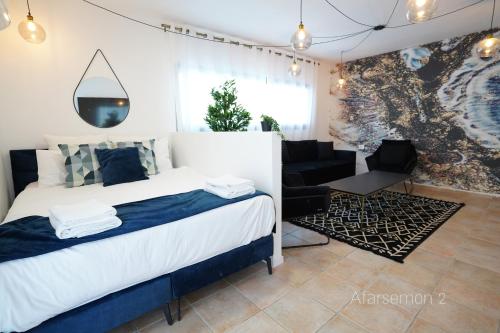 埃拉特YalaRent Afarsemon Apartments with pool - For Families & Couples的一间卧室配有一张床、一把椅子和一张沙发