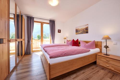 加尔米施-帕滕基兴Ferienwohnung Wetterstein的一间卧室配有一张带红色枕头的大床