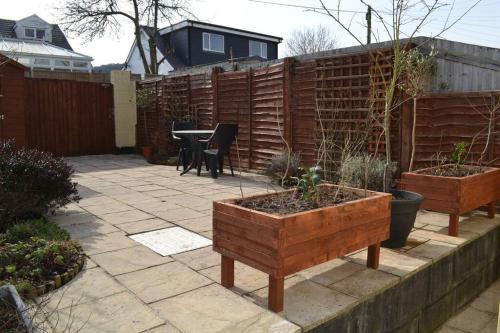卡菲利Entire 3 bedroom house near Caerphilly station的花园设有带桌子和围栏的庭院。