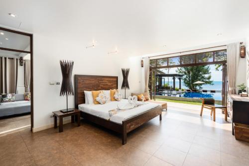 湄南海滩The Emerald Hill Beach Villa的一间卧室设有一张床和一个大窗户