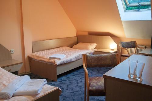 绿山城艾尔普兰酒店的小房间设有一张床、一张桌子和椅子