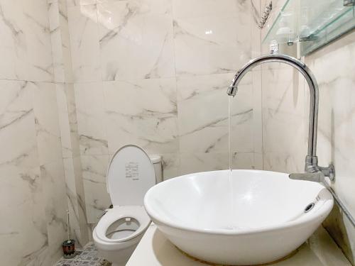 图克图克乐疆度假屋酒店的白色的浴室设有水槽和卫生间。