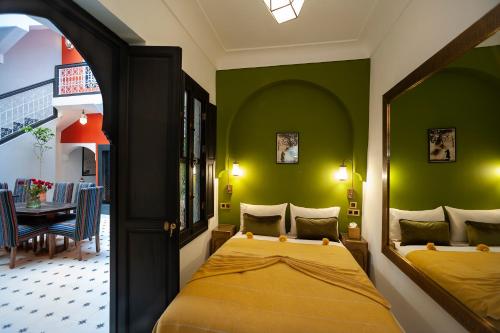 马拉喀什Riad Mylaya的一间设有床铺的卧室,位于一个拥有绿色墙壁的房间