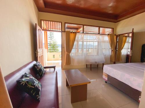 图克图克乐疆度假屋酒店的一间卧室配有一张床、一张沙发和一个窗口