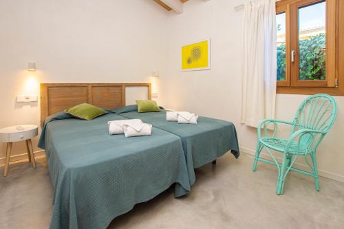 卡拉圣维森特Villa with pool near the beach in Cala San Vicente by Renthousing的一间卧室配有一张带蓝色毯子和椅子的床