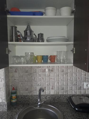 卡博尼格洛Charmant Studio piscine mdiq CaboNégro Martil的厨房柜台设有水槽和一些杯子及盘子