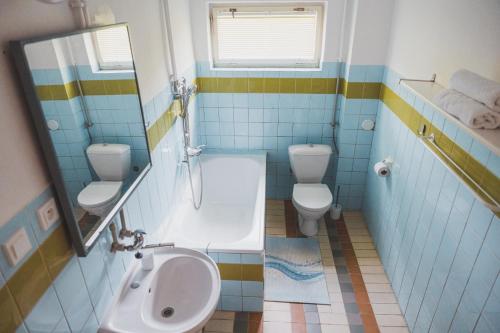VápeniceChalupa U lesa的浴室配有2个卫生间、浴缸和水槽