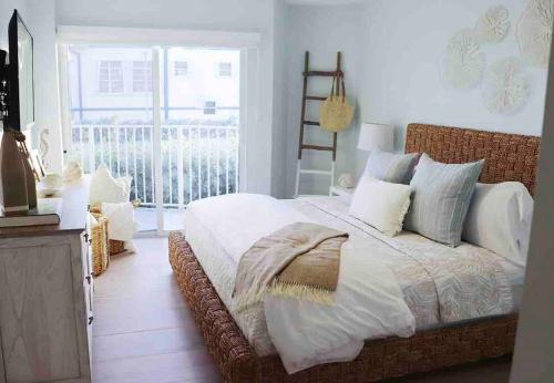 基克罗尼海滩Your Happy Place ON THE BEACH!的一间带大床的卧室和一个阳台