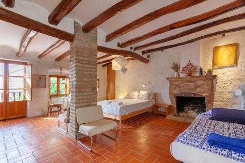 格拉塔略普斯Cal Joanet, acollidora caseta a Gratallops的一间卧室配有一张床和一个壁炉