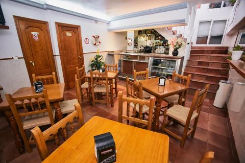 拉安蒂拉阿祖尔旅馆的一间带木桌和椅子的餐厅以及楼梯
