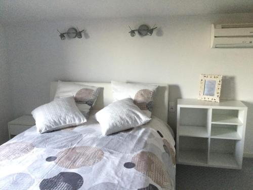 欧布纳les lauriers roses的一间卧室配有一张带两个枕头和镜子的床