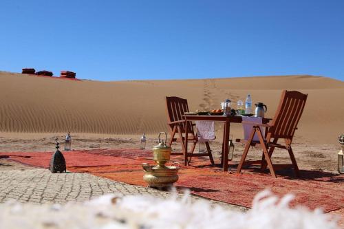 MhamidMhamid camp activités的沙漠中的桌椅,带消防栓
