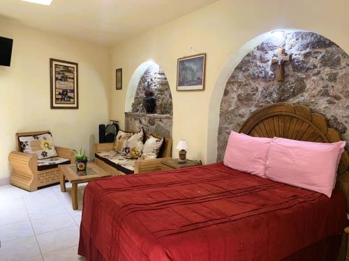 瓜纳华托Noria House in Exhacienda La Escalera的一间卧室设有一张床和石墙