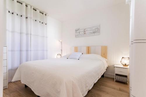 波尔尼克La Terrasse du golf的白色的卧室设有床和窗户