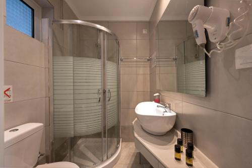 布卡里金色夕阳酒店的带淋浴、卫生间和盥洗盆的浴室