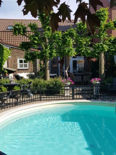 NeerpeltB&B Le Jardin的房屋前的游泳池