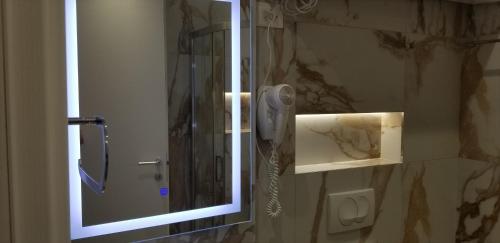 地拉那2A New Bazaar Apartment的浴室内带电话的淋浴