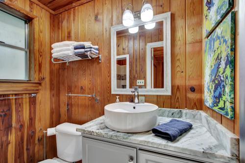 温泉城Lake Haven Cottage On Lake Hamilton的一间带水槽、卫生间和镜子的浴室