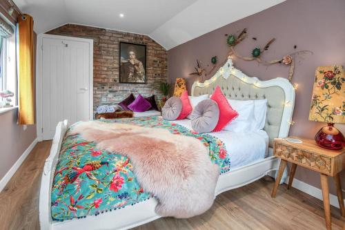 巴尔克施德The Loveshack Lodge Balquhidder的卧室配有白色的床和色彩缤纷的枕头