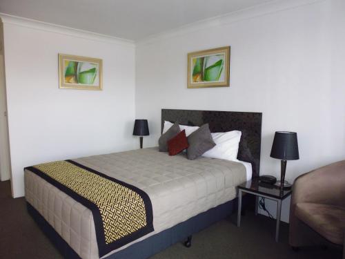 金格罗伊伯克威尔斯汽车旅馆的一间卧室配有一张带两盏灯的床和一张沙发。