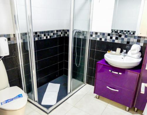 莫甘Apartamentos Guadalupe Gran Canaria Puerto Rico的浴室配有紫色水槽和淋浴