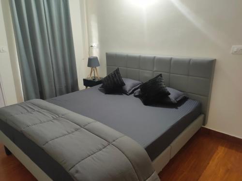 马迪凯里Empra Exotica的卧室里一张带黑色枕头的床