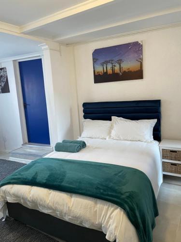开普敦Cub's Home的一间卧室配有一张大床和蓝色床头板