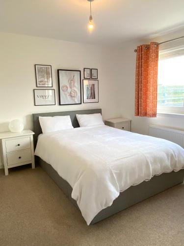 蒙特罗斯Bright 2-bedroom apartment with parking in Montrose的卧室设有一张白色大床和一扇窗户。
