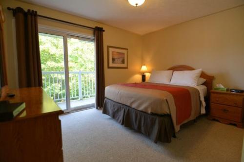 托伯莫里Bruce Anchor Motel and Cruises的一间卧室设有一张床和一个滑动玻璃门